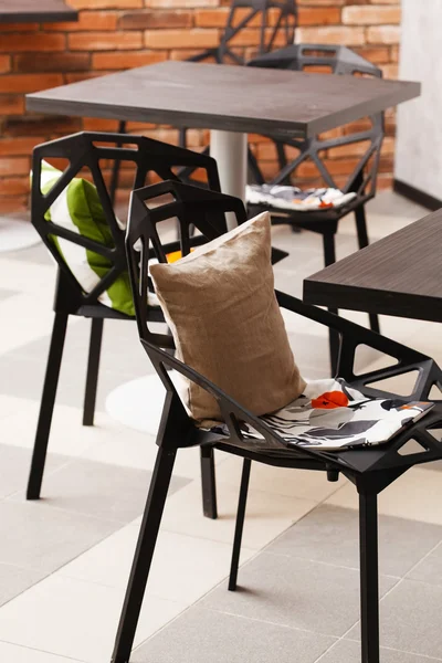 Ahşap masa ve sandalyeler ile dekoratif yastıklar — Stok fotoğraf