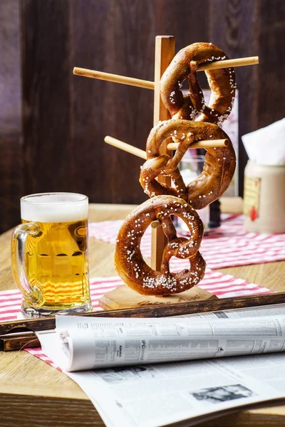 Olut ja Pretzels pöydällä — kuvapankkivalokuva