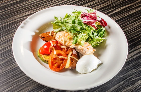 Salmão com legumes no prato — Fotografia de Stock