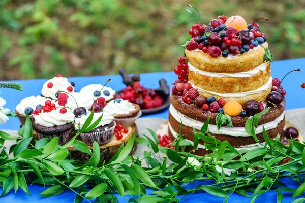 Meztelen esküvői torta és cupcakes a bogyók — Stock Fotó