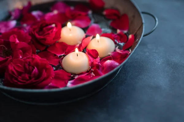 Rode rozen met bloemblaadjes en kaarsen — Stockfoto