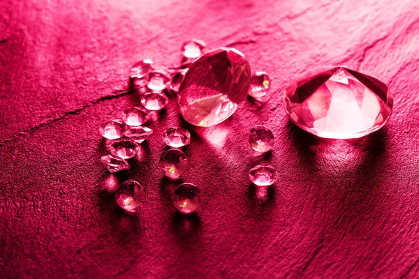 Différents diamants sur fond rouge — Photo