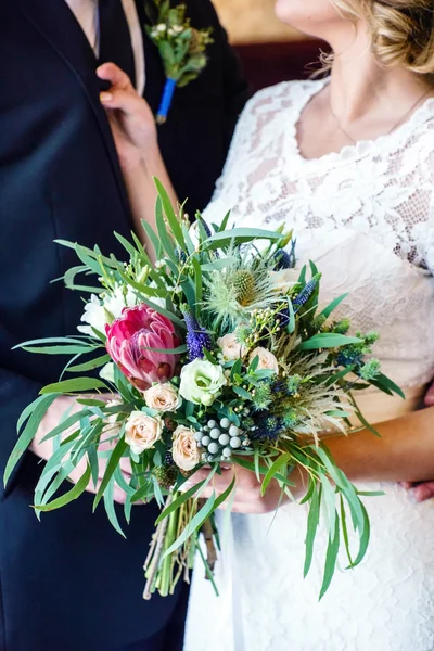 Noivo e noiva segurando flores — Fotografia de Stock