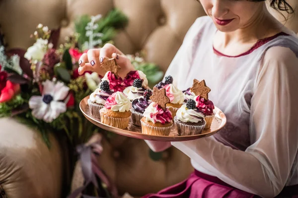 Woman holding Christmas cupcakes — Stock Photo, Image