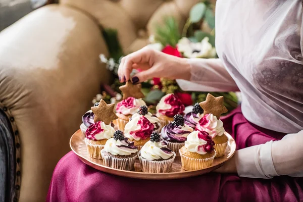 Woman holding Christmas cupcakes — Stock Photo, Image