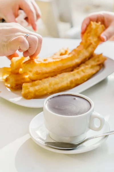 Comer churros saborosos com chocolate — Fotografia de Stock