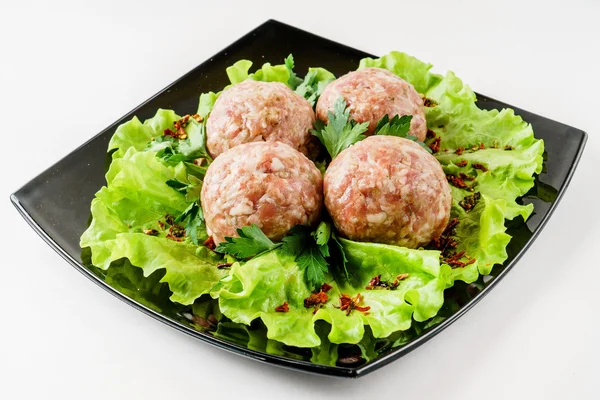 Raw meatballs with green herbs — Stock Photo, Image