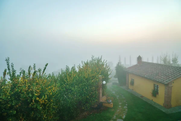 Beautiful cottage in fog — Stock Photo, Image