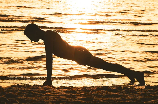 plank exercise on sunset beach