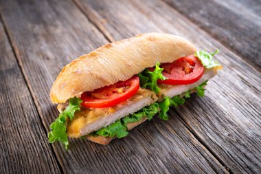 sandwich with fried chickenon wooden background clipart