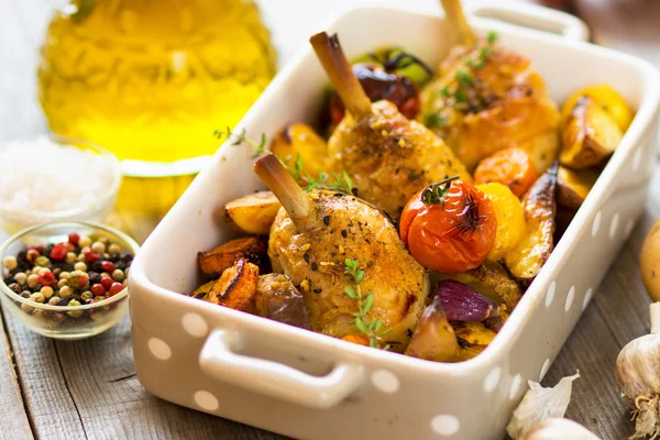 Jambes de poulet cuites au four avec légumes et herbes — Photo