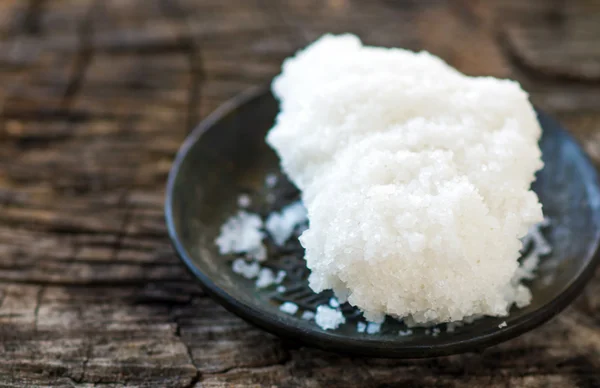 White sugar on black ceramic plate — Stock Photo, Image