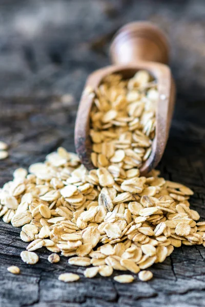 Oat flakes on wooden spoon — Stock Photo, Image