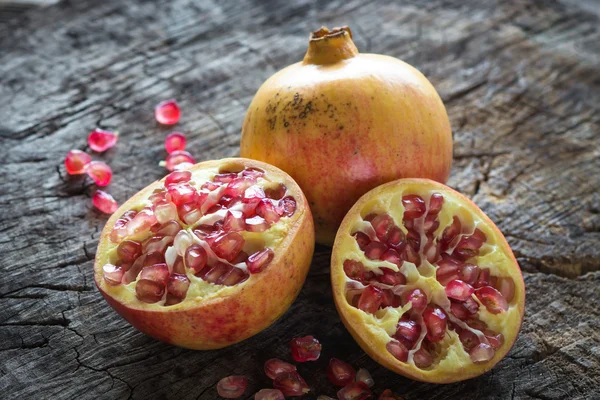 Ganze und in Scheiben geschnittene saftige Granatäpfel — Stockfoto