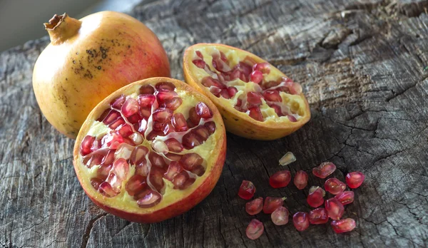 Ganze und in Scheiben geschnittene saftige Granatäpfel — Stockfoto