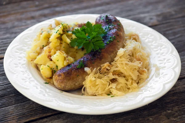 Roasted sausage with sauerkraut and potatoes — Stock Photo, Image