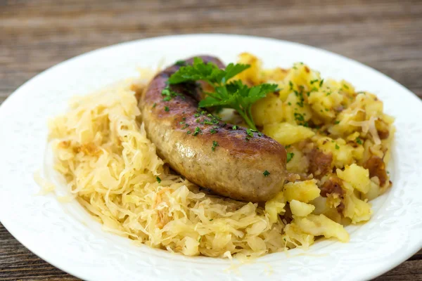 Roasted sausage with sauerkraut and potatoes — Stock Image Roasted sausage with sauerkraut and potatoes Stock Photo