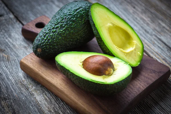 Ganze und in Scheiben geschnittene frische Avocados — Stockfoto