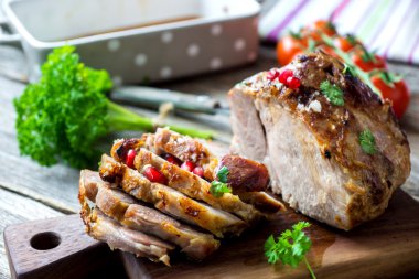 Otlar ve nar ile dilimlenmiş kavrulmuş domuz