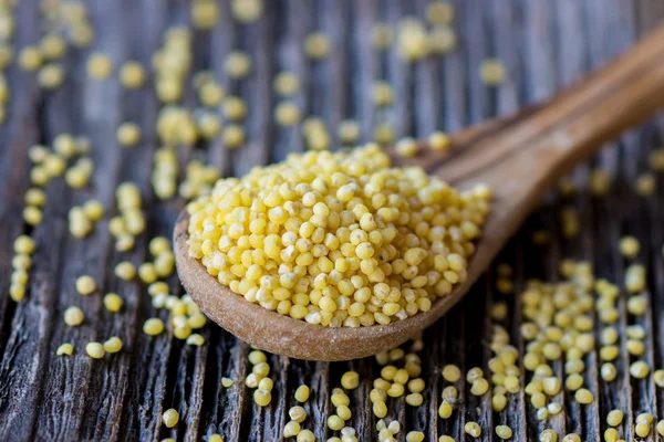 Millet on wooden spoon — Stock Photo, Image
