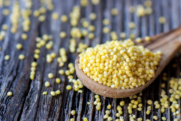 Millet on wooden spoon — Stock Photo, Image