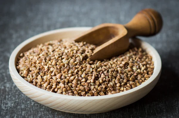 Raw buckwheat in wooden plate — Stock Photo, Image