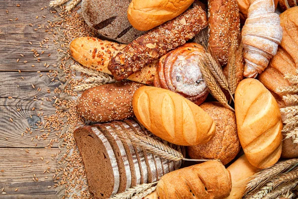 Ahşap Masa Arkasında Pişmiş Ekmek Çeşitleri — Stok fotoğraf