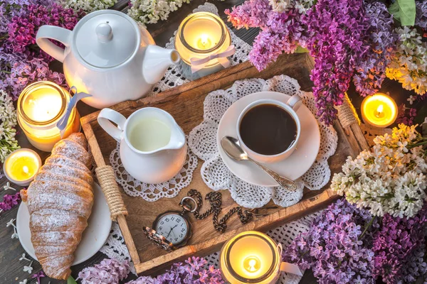 Ramo de lilas, café y velas sobre la mesa — Foto de Stock