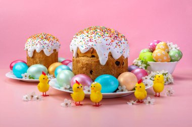 Easter cakes, eggs, chickens. Festive composition on pink background.