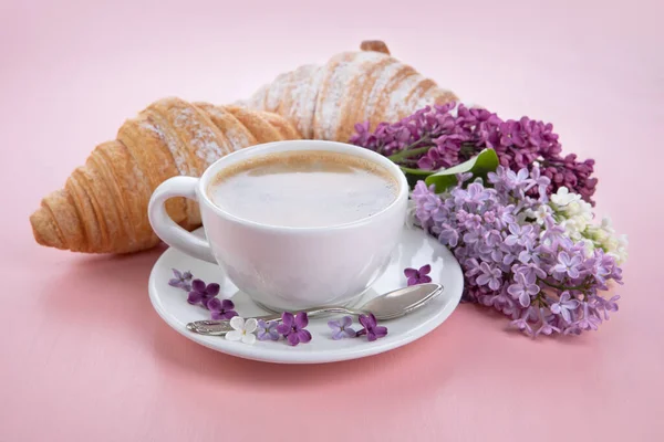 Breakfast with croissant and coffee. Branch lilac.