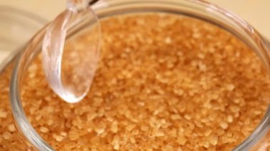 Cam kaşık içinde esmer şeker kamışı şekeri. HD yavaş çekim videosu