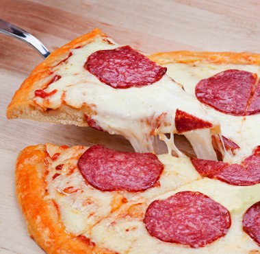 Biberli pizza ahşap üzerine dilimlenmiş