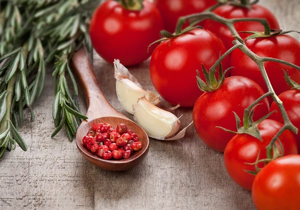 Especiarias e tomates na mesa de madeira — Fotografia de Stock