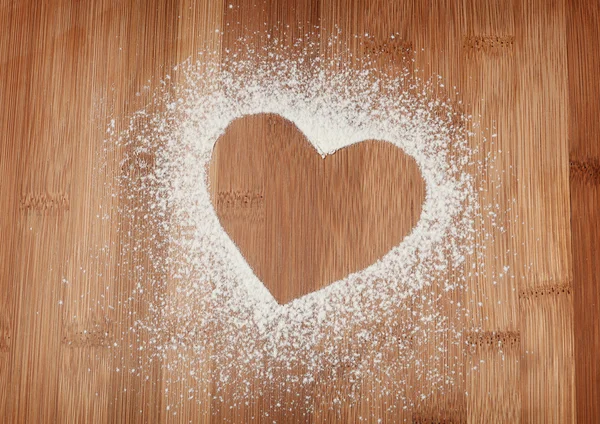 古いボードからテーブルの上に小麦粉の心 — ストック写真