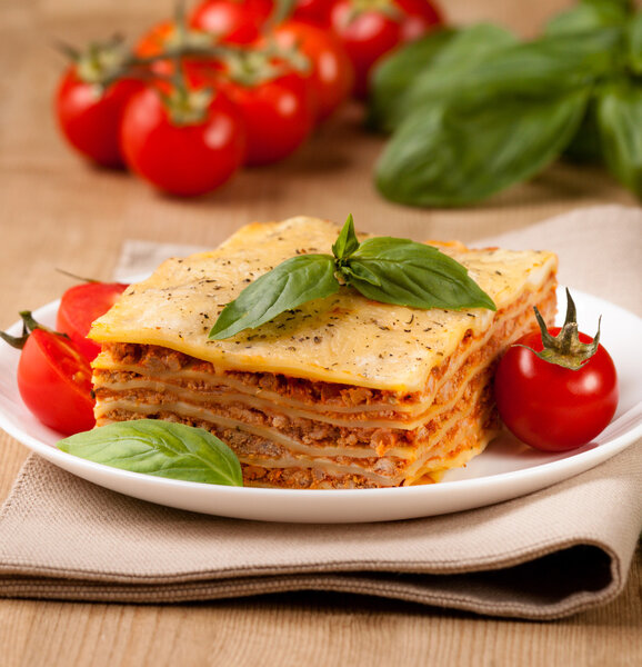 Tasty flavorful lasagna on a plate and ingredients 