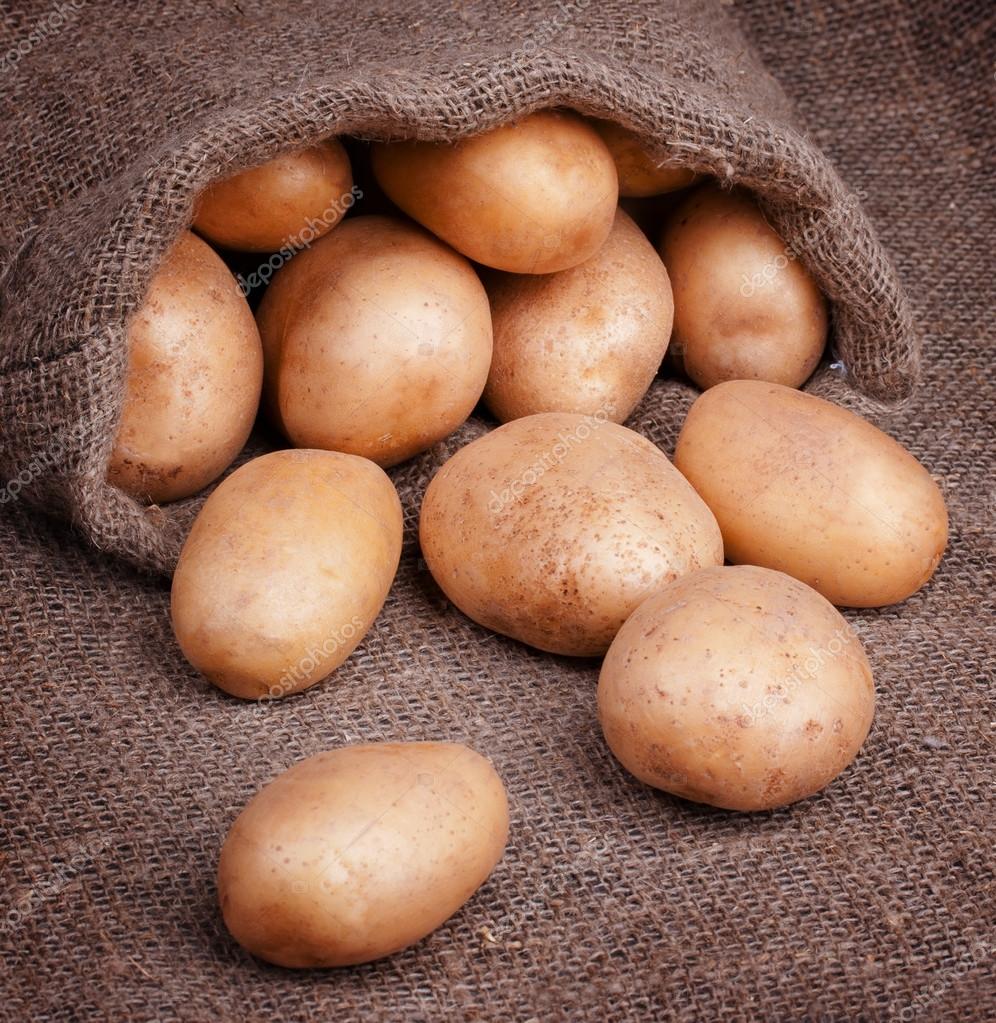 Fresh potatoes in bag — Stock Photo © Timmary 64996729