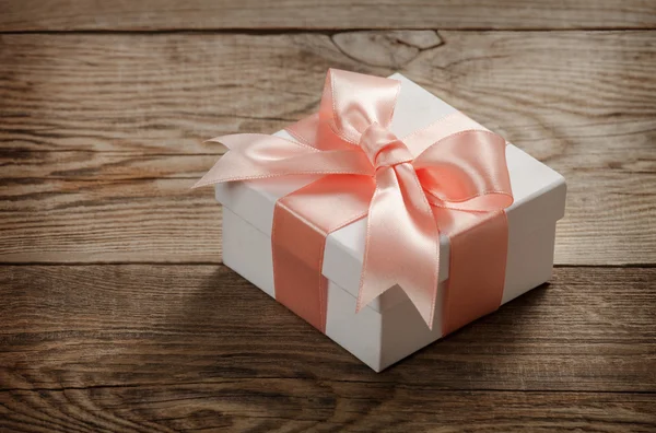 Beautiful gift box with a bow on the table from the old boards — Stock Photo, Image