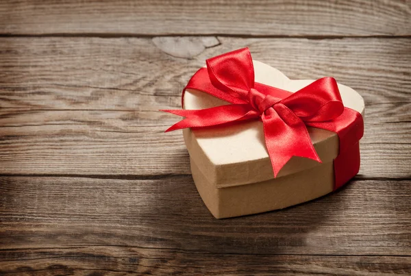 Concepto de regalo. Caja en forma de corazón en las viejas tablas . — Foto de Stock