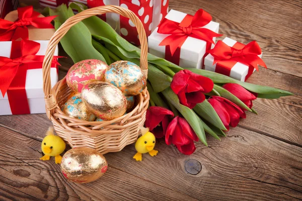 Golden Easter eggs, flowers and gifts — Stock Photo, Image