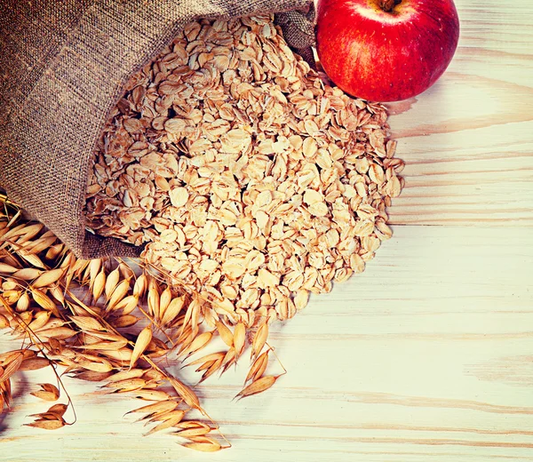 Apple, oats and oat flakes on the table — Stock Photo, Image