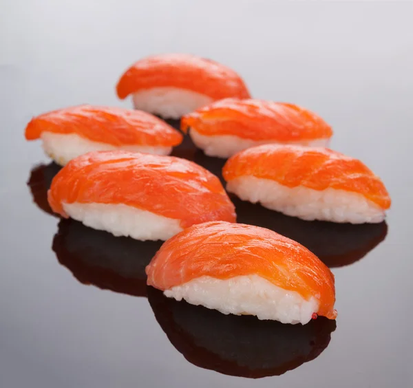 Sushi con salmón rojo sobre fondo negro — Foto de Stock