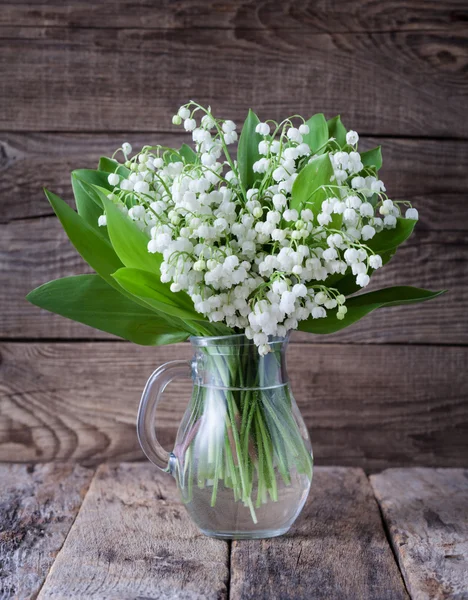 Beaux lis dans un vase en verre sur la vieille table — Photo