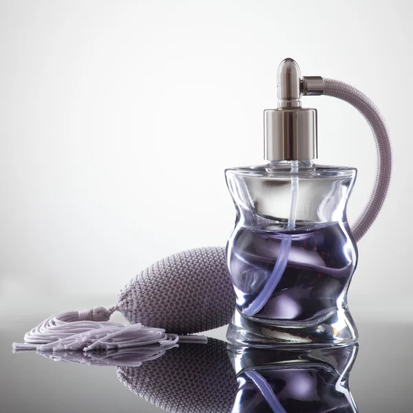 Cosmetic spray perfume on a gray background with reflection — 스톡 사진