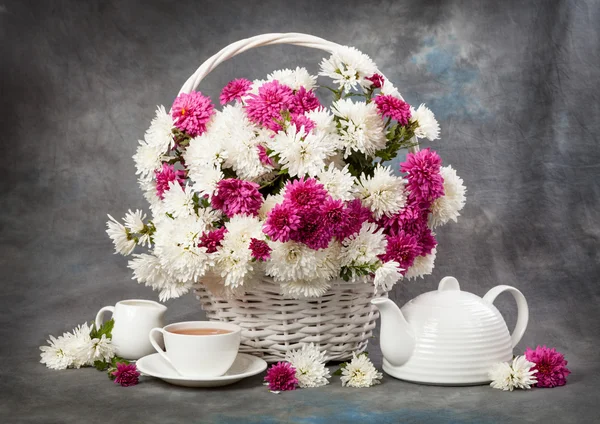 Chrysanthemums in a basket on a wooden table. Still life — Stock Photo, Image