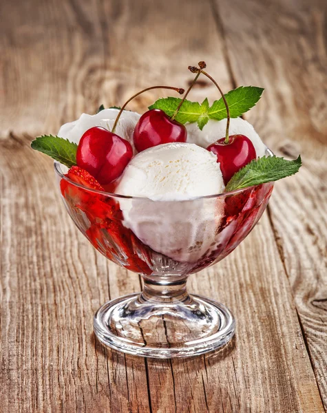 Ice cream with fruits and cherries on old boards