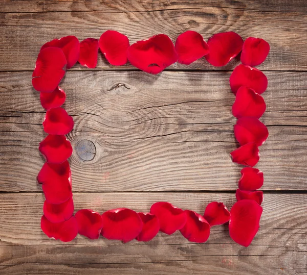 Design element. Frame of rose petals on the old boards — Stock fotografie