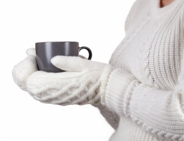 Christmas concept. Coffee cup in female hands dressed in mittens