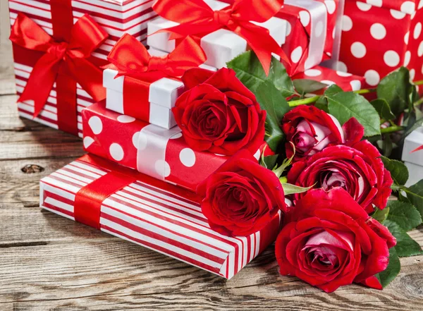 Rosas y cajas con regalos en el tablero — Foto de Stock