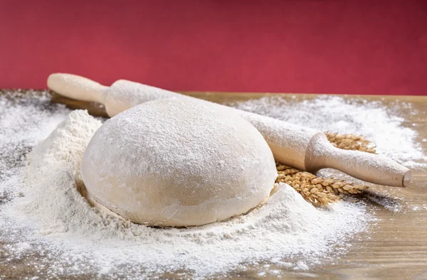 Wooden rolling pin with dough — Stock Photo, Image