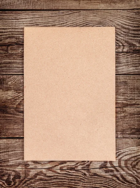 Sheet of brown cardboard on the old board. Design element — Stock Photo, Image